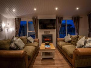 sala de estar con 2 sofás y chimenea en Lodge 8 - The Carse, en Perth