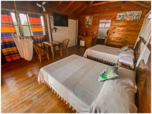 a bedroom with two beds and a table in a cabin at Casa Paraiso Hotel Boutique in Puerto Escondido