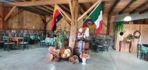 a large room with tables and chairs and flags at Casarão Biazolli in Farroupilha