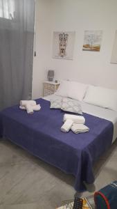 um quarto com uma cama azul com toalhas em Al Centro di Tutto em Palermo