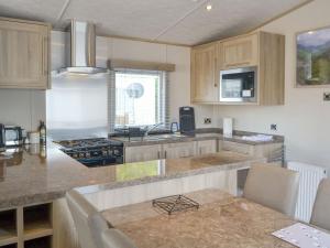 uma cozinha com armários de madeira e uma bancada em Tranquil Lodge - Uk35277 em Brigham