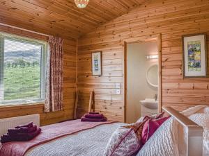 a bedroom with a bed in a log cabin at Islabank Lodge in Auchterarder