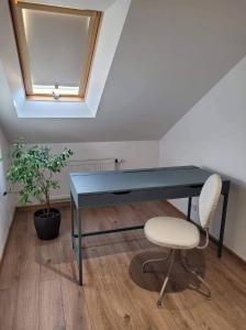 un escritorio azul y una silla en una habitación en Upės apartamentai, en Birštonas