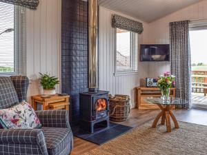 a living room with a wood stove in it at Islabank Lodge in Auchterarder