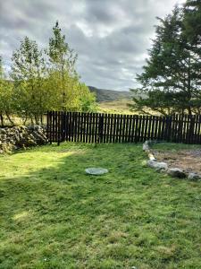a wooden fence in a yard next to a field at Lavender hut in Brackloch