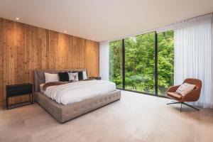 um quarto com uma cama grande e uma cadeira em Luxurious Heaven Lodge Tremblant-4 Bdrs W Hottub em Mont-Tremblant