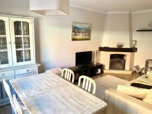 a living room with a table and a fireplace at Diamante Azul Barra Beach Apartment in Praia da Barra