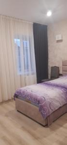 a bedroom with a purple bed and a window at Eco House in Gyumri