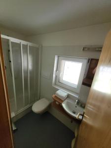 ein Badezimmer mit Toilette, Waschbecken und Fenster in der Unterkunft Gassermühle - Studio Appartments in Eggen