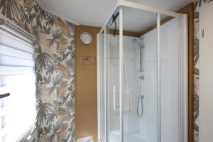 y baño con ducha y puerta de cristal. en Retro 68 : Charmante maison au centre de Malmedy, en Malmedy