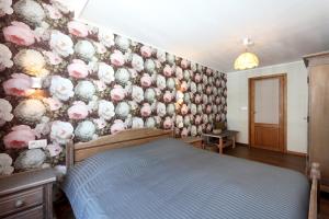 a bedroom with a wall covered in flowers at Retro 68 : Charmante maison au centre de Malmedy in Malmedy