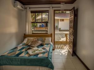 a bedroom with a bed with a view of a balcony at Morada da Sereia in Ilha do Mel