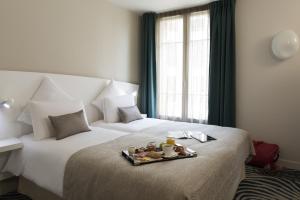a hotel room with a bed with a tray of food on it at Mercure Paris Levallois in Levallois-Perret
