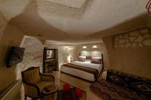 a bedroom with a bed and a chair in a room at FARMER CAVE HOUSE in Ürgüp