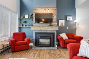 - un salon avec deux chaises rouges et une cheminée dans l'établissement Wintergreen Retreat with Private Sauna & Patio 82291, à Blue Mountains