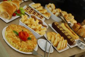 a table topped with different types of food on plates at Hotel Atmosfera Feira de Santana in Feira de Santana