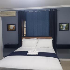 um quarto com uma cama com uma toalha branca em Comfortable & Secure Chateau em Kingston