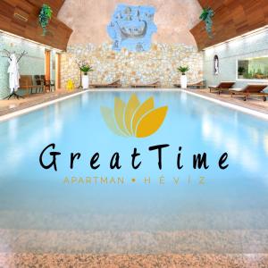 a swimming pool with a resort logo on it at Great Time Apartman in Hévíz