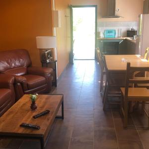 een woonkamer met een bank en een tafel bij eco nature, gite à la ferme in Vendays-Montalivet