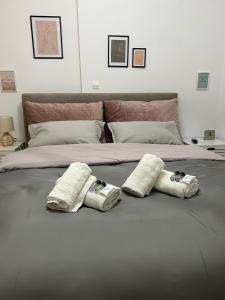 Una cama con tres almohadas encima. en Anastasias apartment tripoli en Tripolis