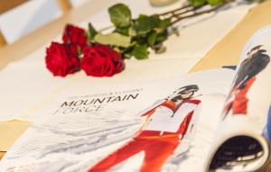 a book on a table with red roses at Villa Alpin in Obergurgl