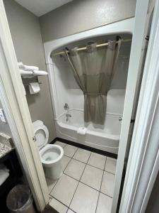 a bathroom with a toilet and a tub with a shower at Super 7 Inn in Memphis