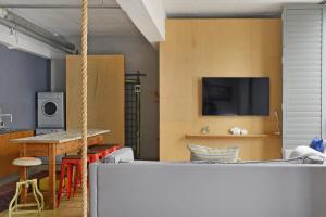 Zimmer mit einem Tisch und einem TV an der Wand in der Unterkunft Harbour Views B101 in Kapstadt