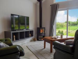 a living room with a fireplace and a tv at Bumble Lodge in Llynclys