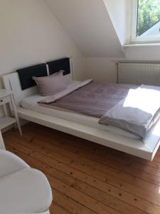 a bedroom with a large white bed with a window at Maya's Place in Leverkusen