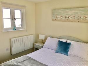 a bedroom with a bed and a picture of birds at Curlew in Brightlingsea