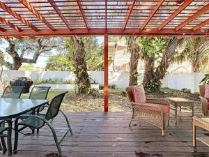 eine Terrasse mit einem Tisch und Stühlen auf einer Holzterrasse in der Unterkunft STEPS FROM THE BEACH, BEST LOCATION, 2 BDRM 2 BTH in Clearwater Beach