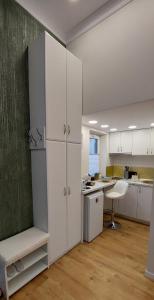 a kitchen with white cabinets and a white refrigerator at Apartament M Vatra Dornei in Vatra Dornei
