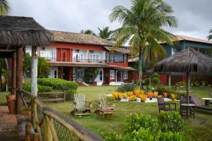 a resort with chairs and tables and a building at Pousada Corumbau in Corumbau