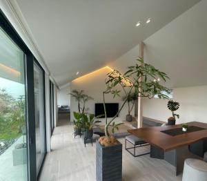 a living room with a table and potted plants at Villa Mariso “貸別荘マリソ“ in Noma