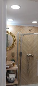 a bathroom with a shower and a sink and a mirror at Apartament M Vatra Dornei in Vatra Dornei