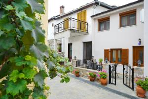 een wit huis met potplanten op een patio bij Villa Oresti in Panayia