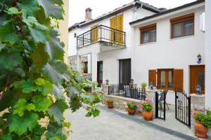 a white house with potted plants on a patio at Villa Oresti in Panagia