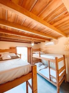Cette chambre dispose de 2 lits superposés et de plafonds en bois. dans l'établissement Caramuru Hostel Caraíva, à Caraíva