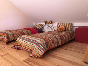 a bedroom with two beds with blankets and a teddy bear at Tiny-House sous les arbres et les oiseaux 