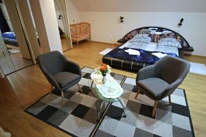 a living room with two chairs and a bed at Beáta Apartman in Gyula
