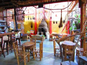 a restaurant with wooden chairs and tables and a fireplace at Hotel Casa Tarzan San Agustin in San Agustín