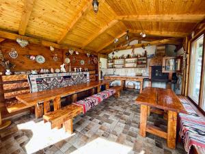 a large room with wooden benches and a kitchen at Casa Andreas in Zărneşti