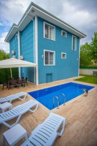 a blue house with a swimming pool in front of it at Antonelya Home in Sapanca