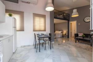 a kitchen and living room with a table and chairs at GAVIDIA CENTER PREMIUM SUITES, FREE PARKING in Seville