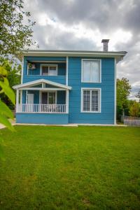 a blue house with a lawn in front of it at Antonelya Home in Sapanca