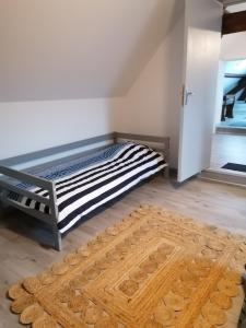1 dormitorio con cama y alfombra en el suelo en LOLA, en Montigny-sur-Crécy