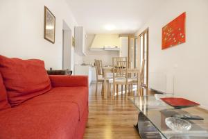 sala de estar con sofá rojo y mesa en B&B La Rocca en San Miniato