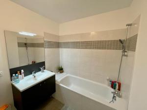 a bathroom with a tub and a sink and a bath tub at Appartement coquet in Marseille