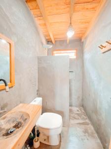 y baño con aseo y lavamanos. en Caramuru Hostel Caraíva en Caraíva