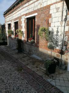 un edificio de ladrillo con plantas a su lado en LOLA, en Montigny-sur-Crécy